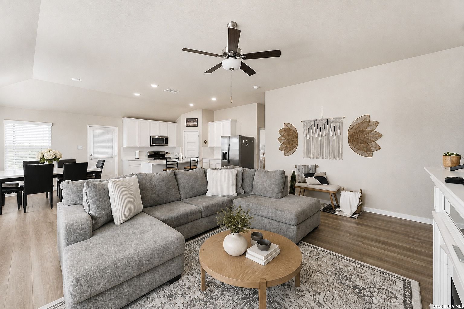 Open living room with sectional, dining area and kitchen beyond