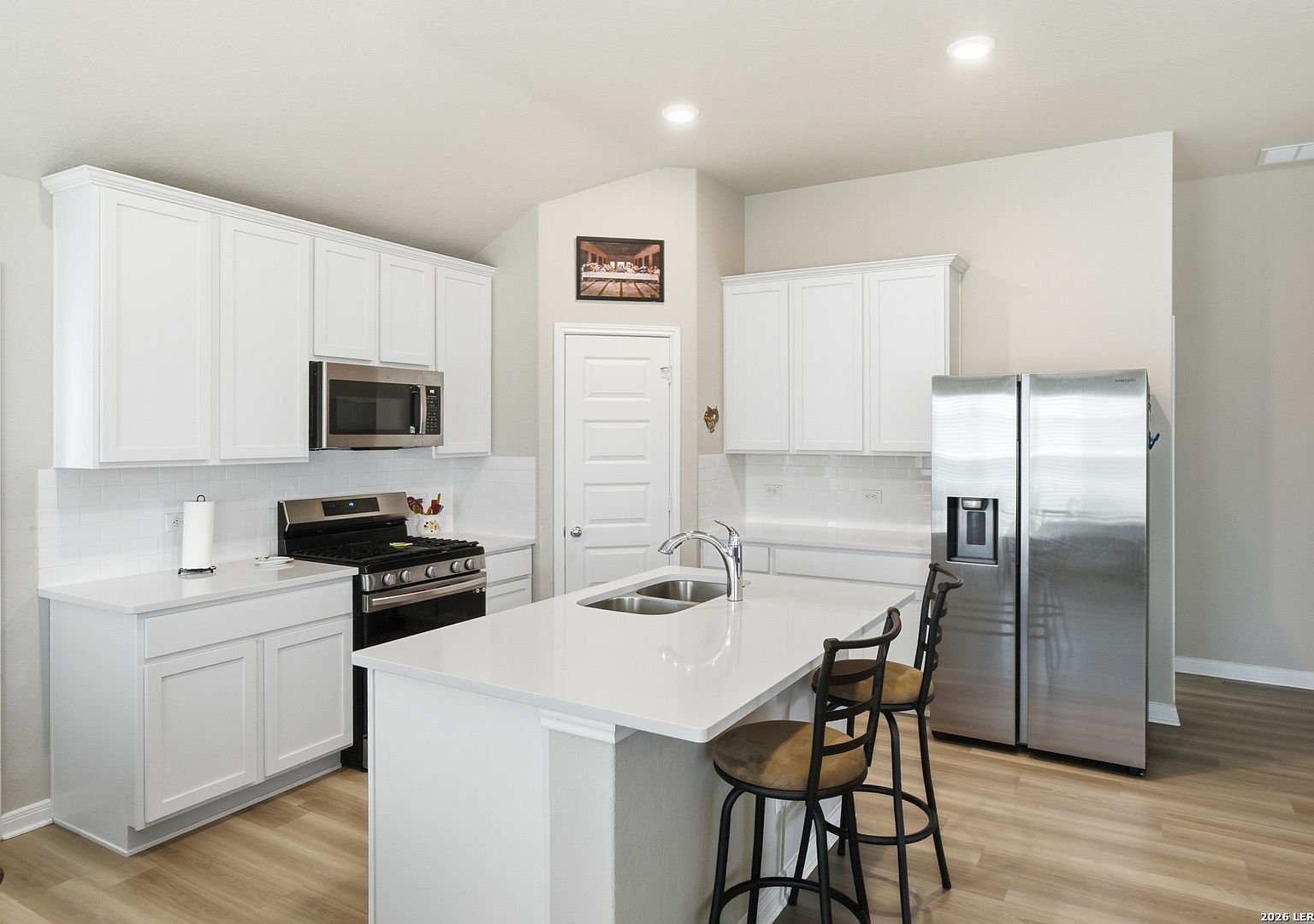 White kitchen with island and stainless appliances