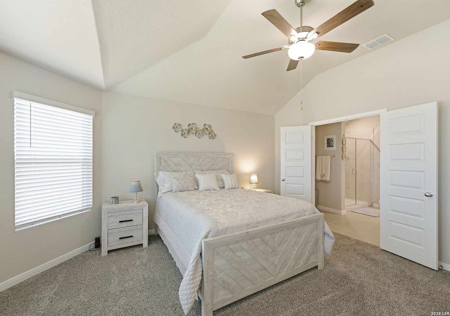 Primary bedroom with vaulted ceiling