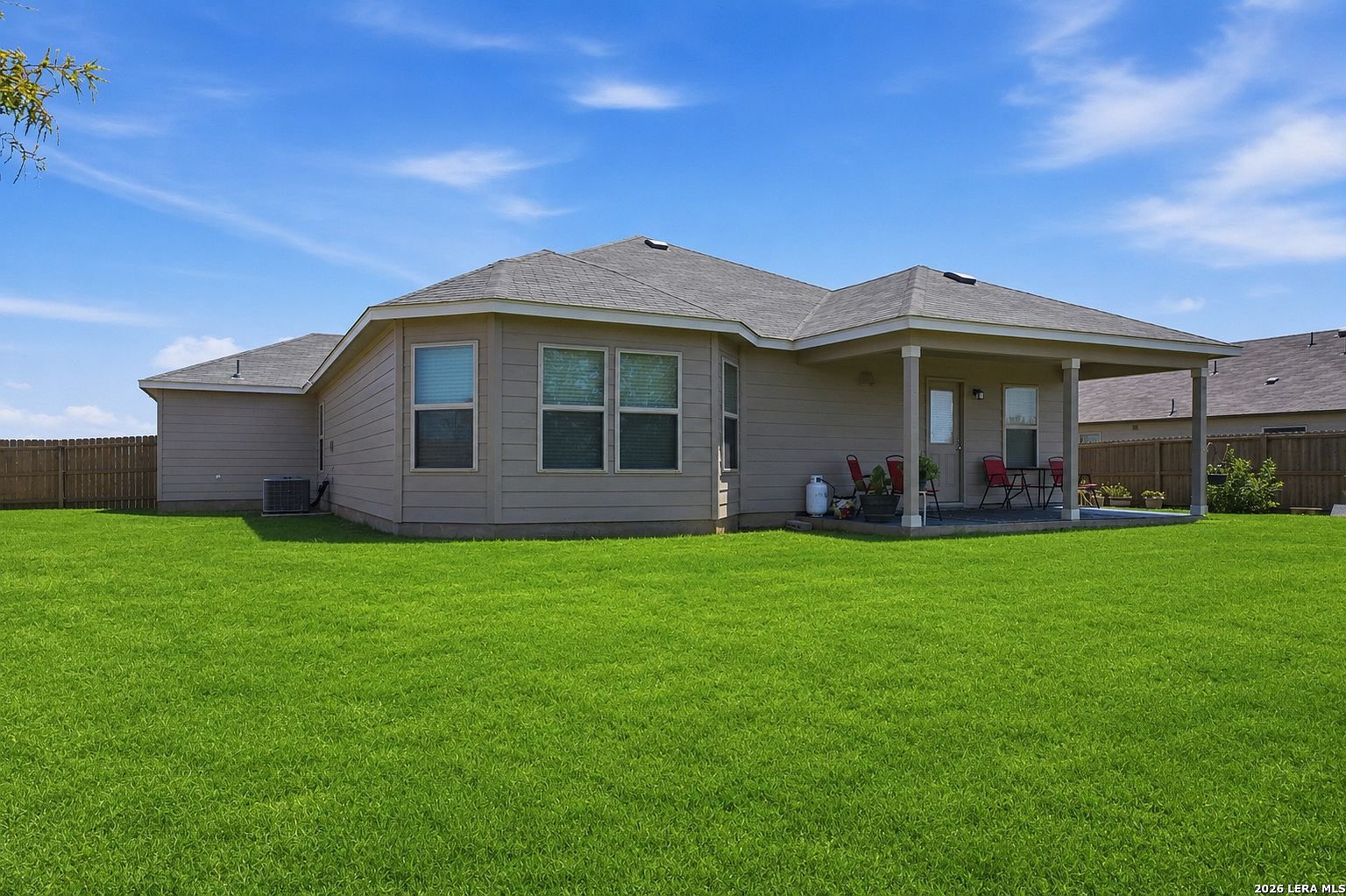 Rear exterior with covered patio and lawn